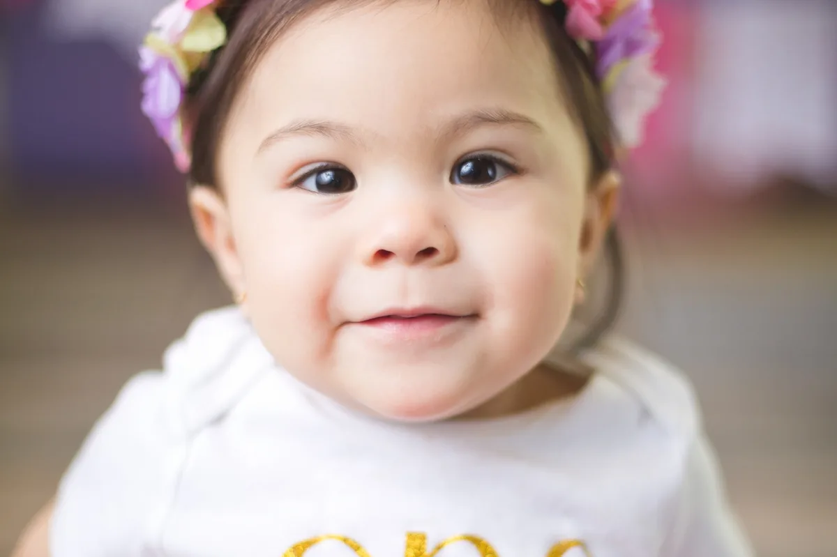 Joyful baby with flower crown during at-home cake smash