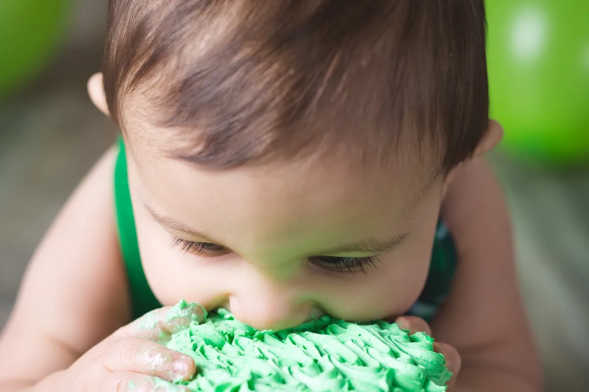 Playful baby with cake and balloons at home smash session