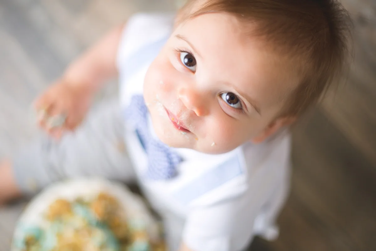 Baby covered in cake during an at-home cake smash photography session in Austin