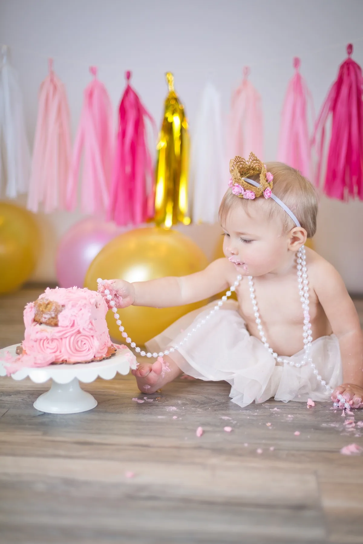 Baby girl with crown and cake at home cake smash session