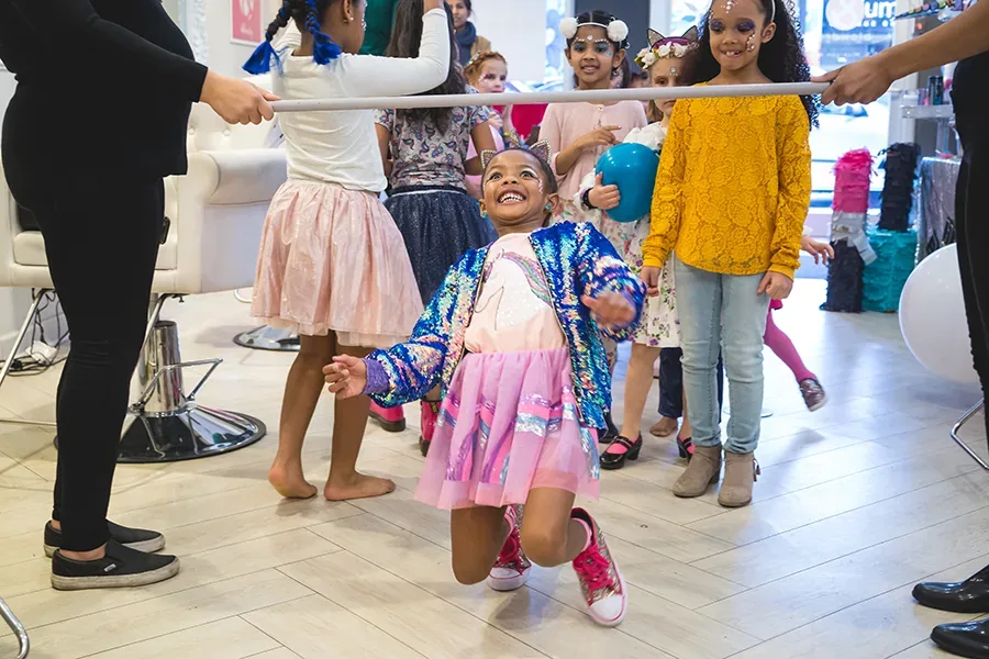 Baby in a playful outfit with balloons and banner at a cake smash session