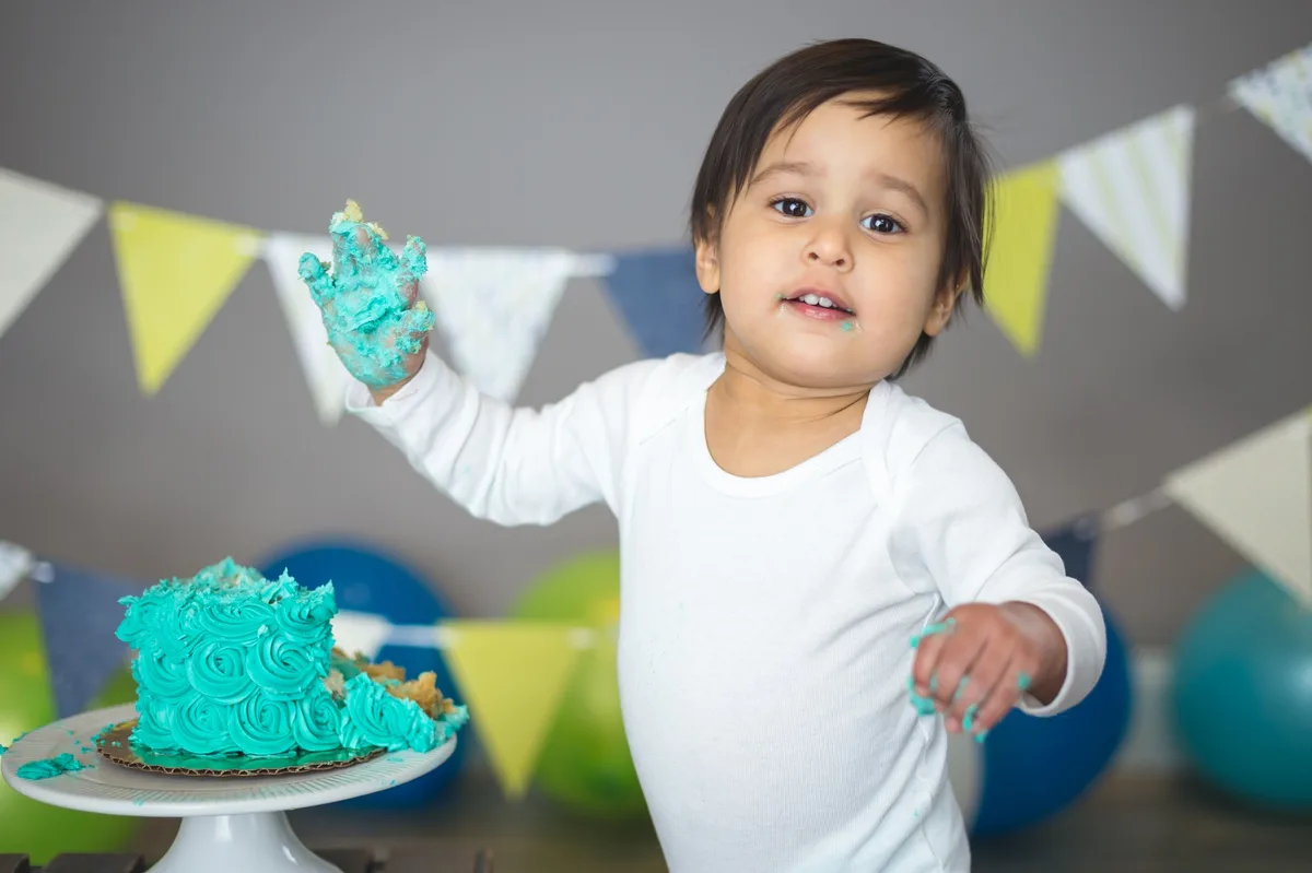 Baby with a teal smash cake and coordinated decorations at a Chicago photography studio