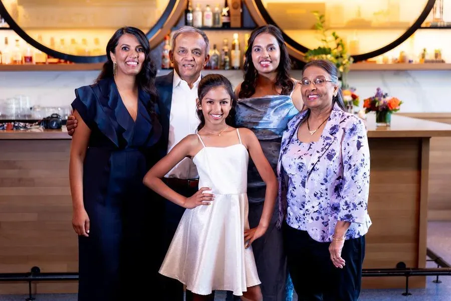 Baby surrounded by balloons, a bow, and a number one sign in a styled professional studio portrait